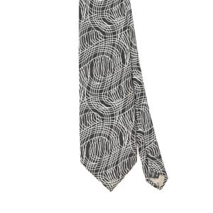 May include: A necktie featuring a dark charcoal grey background with a repeating pattern of thin, white, curved lines that intersect to create a complex, swirling, abstract design. The tie has a pointed tip and a visible fabric label on the back.