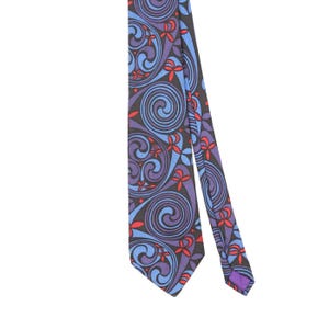 May include: A necktie featuring a dark charcoal background with a repeating pattern of swirling blue and purple spirals. The design is accented with small, bright red floral-like shapes scattered throughout the intricate, flowing graphic print.