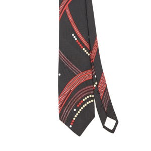 Puede incluir: Una corbata negra con un patrón geométrico de líneas rojas curvas y filas de pequeños puntos blancos y rojos. La tela tiene una textura diagonal sutil y el diseño crea una serie de arcos que se cruzan a través de la superficie.