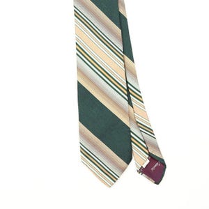 May include: A necktie featuring a diagonal striped pattern in shades of dark green, beige, white, and brown. The tie has a pointed end and a dark purple fabric label on the interior lining with the brand name Cassini printed in white script text.