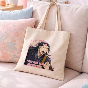 Könnte beinhalten: Beige Tragetasche mit einer Cartoon-Illustration eines Charakters mit langen schwarzen Haaren und einer rosa Schleife. Der Text auf der Tasche lautet: "I'll get over it. I just need to be dramatic first."