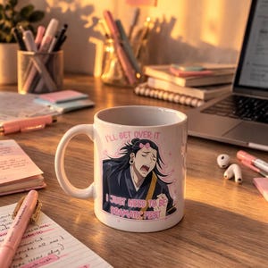 Può includere: Tazza in ceramica bianca con manico, con un'illustrazione di un personaggio anime e il testo "I'LL GET OVER IT, I JUST NEED TO BE DRAMATIC FIRST." La tazza è su una scrivania di legno con articoli di cancelleria.