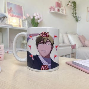 May include: A white ceramic mug featuring a graphic illustration of an anime-style character with short brown hair and a smirk. The text "Girl, NO." is printed in red above and below the character, surrounded by several small red flag icons.