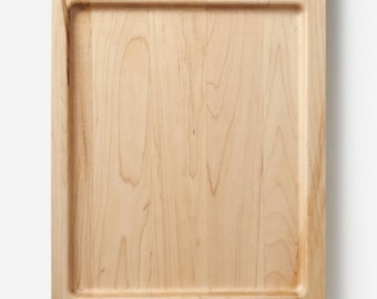 May include: Rectangular wooden serving tray with two curved handles. The tray is made of light-colored wood with visible grain patterns. The edges are slightly raised, creating a defined serving area. A simple, functional design for serving food or displaying items.