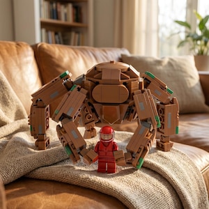 May include: A brown Lego spider-like model with articulated legs and a red Lego figure in a red jumpsuit and helmet. The model has green and gray accents. The scene is set on a brown leather couch with a beige blanket.