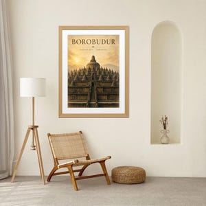 May include: A framed wall art print featuring the Borobudur temple in Central Java, Indonesia. The image displays the stone structure under a golden sunrise sky with the text BOROBUDUR and Central Java, Indonesia printed at the top.