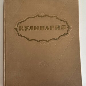Könnte beinhalten: Beigefarbenes Vintage-Kochbuch mit dem kyrillischen Wort "КУЛИНАРИЯ" in goldfarbenen Buchstaben. Das Cover hat ein Rautenmuster und einen verzierten goldenen Rahmen um den Titel. Das Jahr "1959" ist unten geprägt.