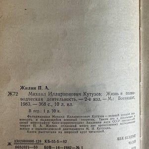 K&ouml;nnte beinhalten: Eine beige Buchseite mit schwarzem russischem Text. Der Text enth&auml;lt den Autor Zhilin P. A., den Titel Mikhail Illarionovich Kutuzov: Zhizn i polkovodcheskaya deyatelnost, Publikationsdetails von 1983 sowie verschiedene bibliografische Codes.