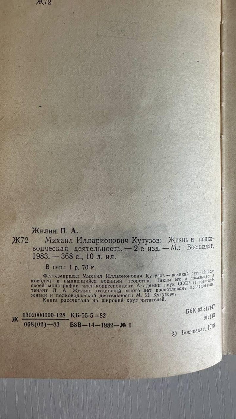 K&ouml;nnte beinhalten: Eine beige Buchseite mit schwarzem russischem Text. Der Text enth&auml;lt den Autor Zhilin P. A., den Titel Mikhail Illarionovich Kutuzov: Zhizn i polkovodcheskaya deyatelnost, Publikationsdetails von 1983 sowie verschiedene bibliografische Codes.