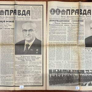 Könnte beinhalten: Zwei alte Ausgaben der sowjetischen Zeitung Prawda, gedruckt auf gealtertem, cremefarbenem Papier mit schwarzer Tinte. Jede Titelseite zeigt den Zeitungskopf mit Porträts von Lenin und Marx, ein großes Foto von Juri Andropow und kyrillische Texte.