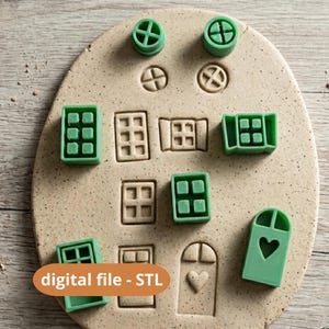 Könnte beinhalten: Eine Sammlung grüner Ausstecher und Stempel in Hausform, darunter Fenster, Türen und Dachdetails, angeordnet auf einer beigen Oberfläche. Der Text "digital file - STL" wird auf einem orangefarbenen Etikett angezeigt.