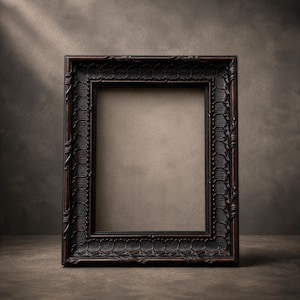 May include: A dark brown, rectangular picture frame with detailed carvings. The frame has a textured finish and a traditional design. The empty space within the frame is a neutral tan colour, contrasting with the dark frame.