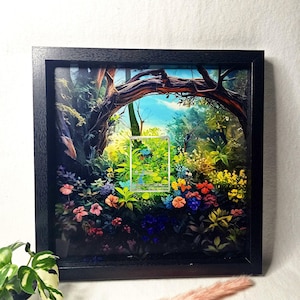 Könnte beinhalten: Ein quadratischer schwarzer Schattenfugenrahmen mit einem mehrschichtigen 3D-Papierkunstwerk, das einen üppigen Wald mit einer zentralen Sammelkarte zeigt. Das Bild enthält leuchtende Blumen in Rot-, Blau- und Gelbtönen unter einem Ast.