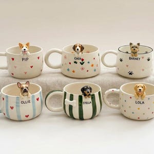 Può includere: Sei tazze in ceramica, ognuna con una piccola statuetta di cane tridimensionale che sporge dal bordo. Le tazze sono decorate con vari motivi, tra cui cuori rossi, fiori colorati, impronte di zampe nere, strisce blu, strisce verdi e pois.