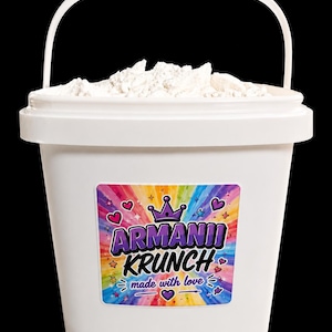 Könnte beinhalten: Ein weißer Plastikeimer mit Griff, gefüllt mit einer weißen Substanz. Der Eimer hat ein farbenfrohes Etikett mit der Aufschrift "Armanii Krunch" mit einer Krone und Herzen sowie den Worten "made with love".