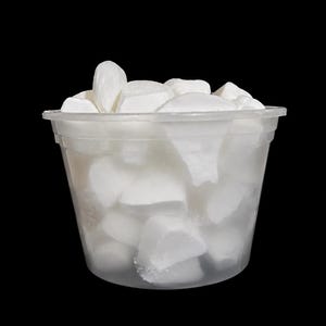 May include: A clear plastic container filled with numerous irregular, solid white chunks. The container has a slightly tapered cylindrical shape with a visible rim at the top, holding a collection of opaque white pieces of varying sizes and shapes.