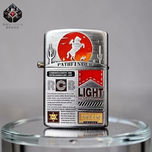 May include: A silver-toned metal lighter with a red and orange circular design featuring a horse and rider. The lighter has the word "PATHFINDER" and the text "LIGHT THE FIRE OF YOUR LIFE".