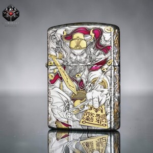 May include: Silver metal lighter with an engraved design. The design features a warrior figure with a sword, wearing a helmet and ornate clothing. Gold and red accents add colour to the detailed illustration.