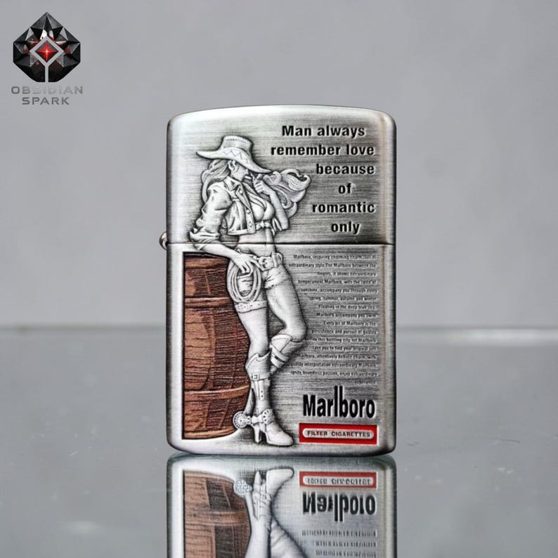 May include: Silver-colored metal lighter with a detailed engraving of a woman in a cowboy hat and shorts, leaning against a barrel. The lighter has the text "Man always remember love because of romantic only" and "Marlboro Filter Cigarettes".