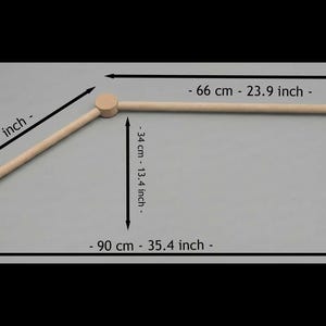 May include: A light-colored wooden baby mobile arm with measurements in inches and centimeters. The arm is 35.4 inches (90 cm) long, with a 23.9-inch (66 cm) horizontal bar and a 16.9-inch (43 cm) angled support.