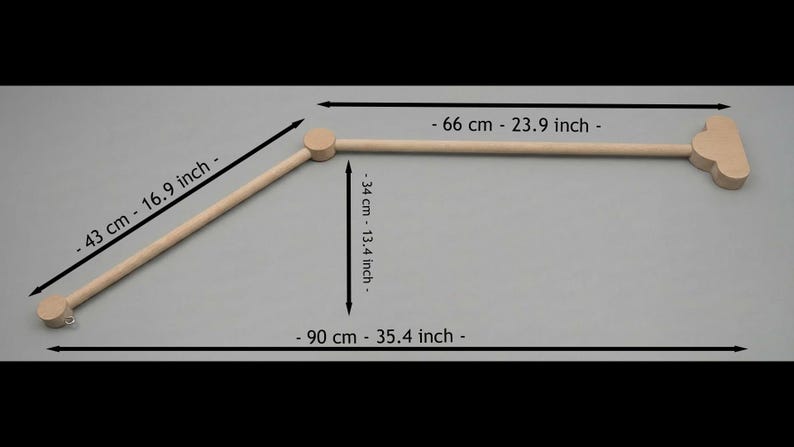 May include: A light-colored wooden baby mobile arm with measurements in inches and centimeters. The arm is 35.4 inches (90 cm) long, with a 23.9-inch (66 cm) horizontal bar and a 16.9-inch (43 cm) angled support.