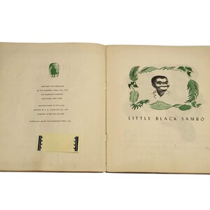 May include: Open book with the title page of "Little Black Sambo". The illustration features a black and white image of a person's face surrounded by green leaves. The text "Little Black Sambo" is below the image.