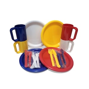 May include: A collection of colorful plastic tableware, including plates, mugs, and wrapped cutlery. The set features plates in white, yellow, red, and blue, with matching mugs in red, yellow, and blue. Cutlery sets include forks, knives, and spoons.