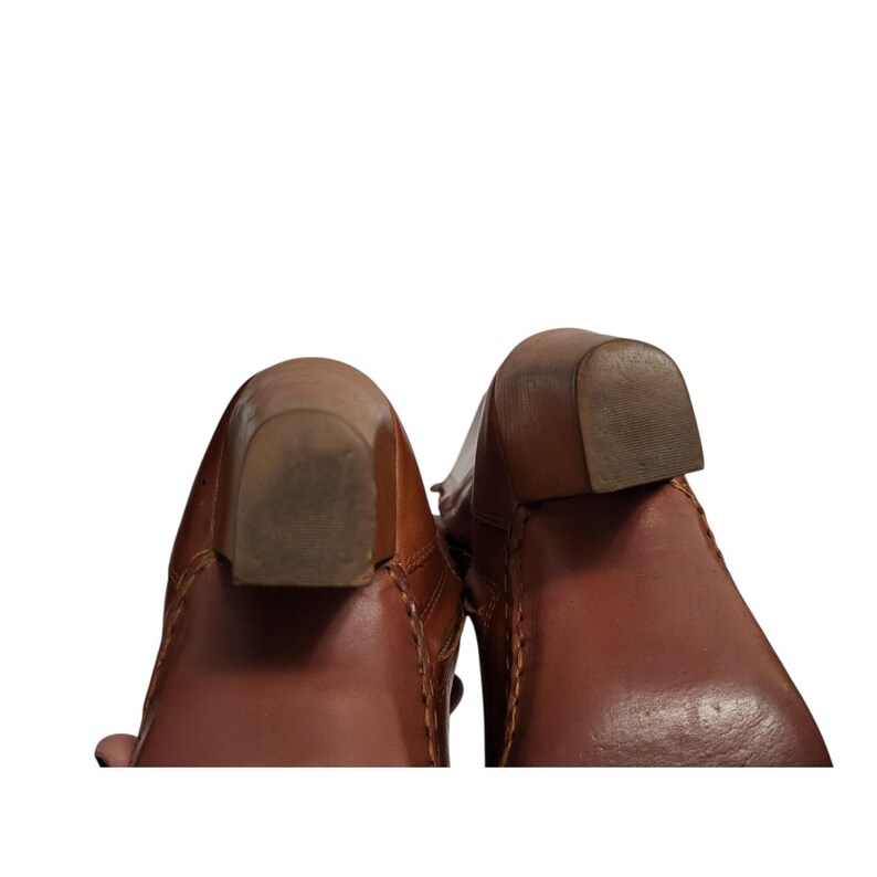 K&ouml;nnte beinhalten: Nahaufnahme von zwei braunen Lederstiefeln. Die Stiefel haben einen Blockabsatz und sichtbare Nahtdetails. Die Abs&auml;tze sind aus einem helleren braunen Material und weisen Abnutzungserscheinungen auf.