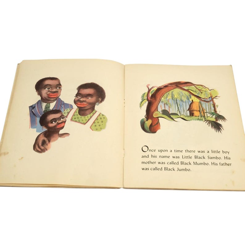 May include: Open book with illustrations and text. The left page shows three figures with dark skin and red lips. The right page has a colorful illustration of a hut and text that reads "Once upon a time there was a little boy and his name was Little Black Sambo."