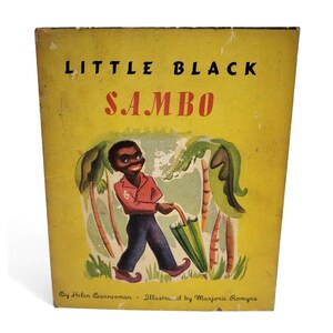 May include: Vintage children's book titled "Little Black Sambo" with a yellow cover. The cover features an illustration of a smiling boy in a red shirt and blue pants holding a green umbrella. The book is by Helen Bannerman and illustrated by Marjorie Romyns.