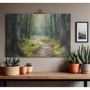 Puede incluir: Una gran pintura de paisaje representa un sendero forestal que conduce a la luz. La obra de arte está montada en una pared sobre una mesa de madera. Varias plantas en macetas, incluyendo suculentas y cactus, están dispuestas sobre la mesa.