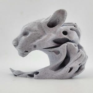 May include: A light grey, speckled 3D printed sculpture of a feline head and neck. The design features an abstract, fluid, and organic form with hollowed-out sections and layered textures throughout the entire structure of the animal figure.