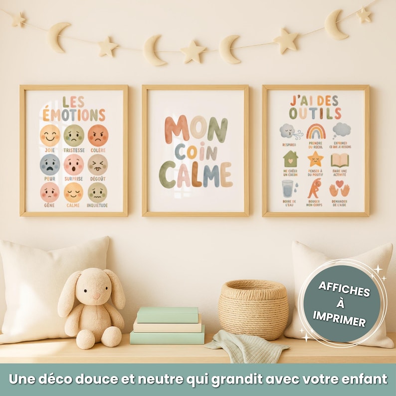 Op de afbeelding: Drie ingelijste prints met tekst en illustraties hangen aan een muur. De prints zitten in houten frames. De tekst op de prints bevat "LES &Eacute;MOTIONS", "MON COIN CALME" en "J'AI DES OUTILS". Een knuffelkonijn, boeken en een rieten mand staan eronder.