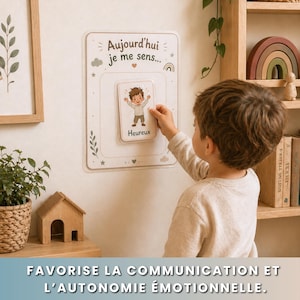 May include: A child interacting with a white board featuring the text "Aujourd'hui je me sens..." and a card that says "Heureux". The board has decorative elements like stars, clouds, and a rainbow. The bottom of the image has the text "FAVORISE LA COMMUNICATION ET L'AUTONOMIE &Eacute;MOTIONNELLE."