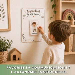 May include: A child interacting with a white board featuring the text "Aujourd'hui je me sens..." and a card that says "Heureux". The board has decorative elements like a rainbow, clouds, and stars. The bottom of the image has the text "FAVORISE LA COMMUNICATION ET L'AUTONOMIE &Eacute;MOTIONNELLE."