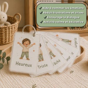 May include: A set of emotion flashcards on a metal ring. Each card features an illustration of a child and a corresponding emotion word. The cards include the words "Heureux", "Triste", and "F&acirc;ch&eacute;". The text on the image says "Aide &agrave; nommer les &eacute;motions".