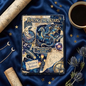Op de afbeelding: Een doorzichtige hoes met een fantasieontwerp met een draak, maan en sterren. De teksten "Among the Stars", "Dragon Rider Reader" en "Written in Stardust" zijn zichtbaar. De hoes ligt op een blauwe satijnen ondergrond met gouden sterren en een kop koffie.