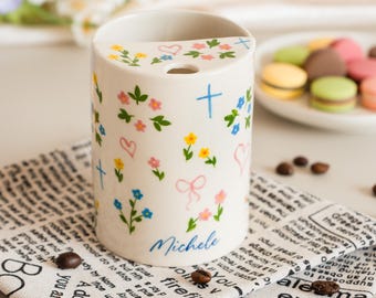 Taza de viaje de cerámica con diseño floral pintado a mano y nombre personalizado.