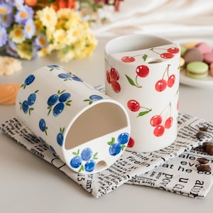 Tazza da viaggio in ceramica fatta a mano con decorazione dipinta a mano sottosmalto a tema mirtilli o ciliegie – Regalo ideale per gli amanti del caffè