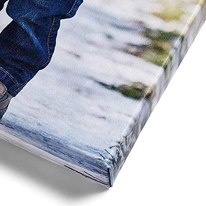 May include: Close-up of a canvas print with a wrapped edge. The canvas displays a blurred image with shades of blue, white, and green. The corner of the canvas is visible, showing the wrapped and stapled construction.