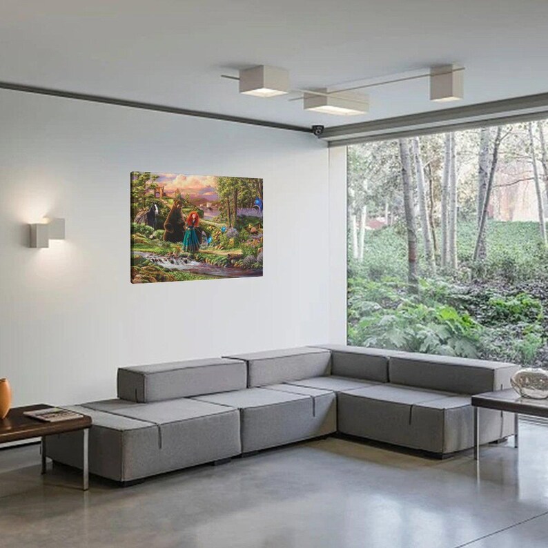 May include: A framed canvas art print depicting a colorful scene with characters in a forest setting. The artwork features a woman with red hair and a bear. The print is displayed on a white wall above a gray sectional sofa.
