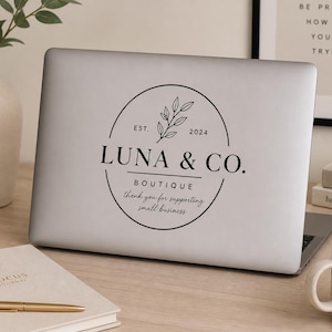Business window vinyl decal with custom logo and hours displayed on laptop for small business branding