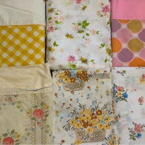 Puede incluir: Una colección de seis piezas de tela dobladas con varios patrones, incluyendo cuadros vichy amarillos, círculos rosas y morados, y múltiples diseños florales con ramos, cestas y flores dispersas sobre fondos blancos y crema.