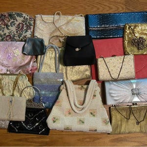 Può includere: Una collezione di borse vintage in vari stili e colori. Include pochette, borse con perline e borse a mano. Presenta motivi floreali, finiture metalliche e abbellimenti decorativi. Sono esposte una varietà di dimensioni e forme.