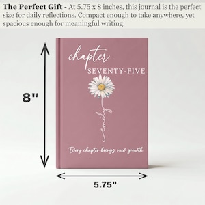 May include: A dusty rose journal measuring 5.75 by 8 inches. The cover features a white daisy illustration, the text "chapter SEVENTY-FIVE", the name "emily" in script, and the phrase "Every chapter brings new growth" in white lettering.