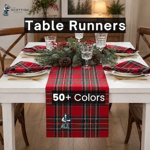 Puede incluir: Un camino de mesa a cuadros rojos con detalles verdes y amarillos se muestra sobre una mesa blanca, preparada para una comida festiva. La imagen incluye el texto "Table Runners" y "50+ Colors". También se ven servilletas y manteles individuales a juego.