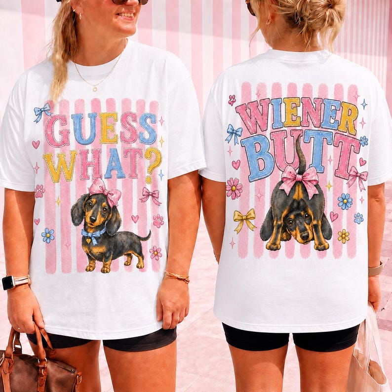 May include: White t-shirts with a dachshund dog graphic. The front of the shirt says "GUESS WHAT?" in pink, yellow, and blue. The back says "WIENER BUTT" with a graphic of a dog's rear end.
