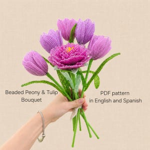Pode incluir: Um buquê de flores feitas à mão com miçangas, apresentando uma peônia central rosa-escura cercada por várias tulipas roxas claras. Cada flor é construída com pequenas miçangas com caules e folhas verdes. O texto diz Beaded Peony & Tulip Bouquet PDF pattern in English and Spanish.