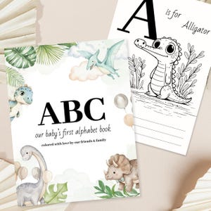 Może przedstawiać: Książka z alfabetem dla dzieci z literami "ABC" na okładce, ilustracjami dinozaurów i tekstem "our baby's first alphabet book." Otwarta strona przedstawia ilustrację aligatora z literą "A" i słowami "is for Alligator."