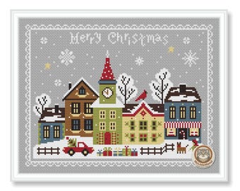 May include: Cross-stitch artwork of a snowy Christmas village scene. The image features several colorful houses, a red car with a Christmas tree, and the words "Merry Christmas" at the top. Snowflakes and a small fence are also included.